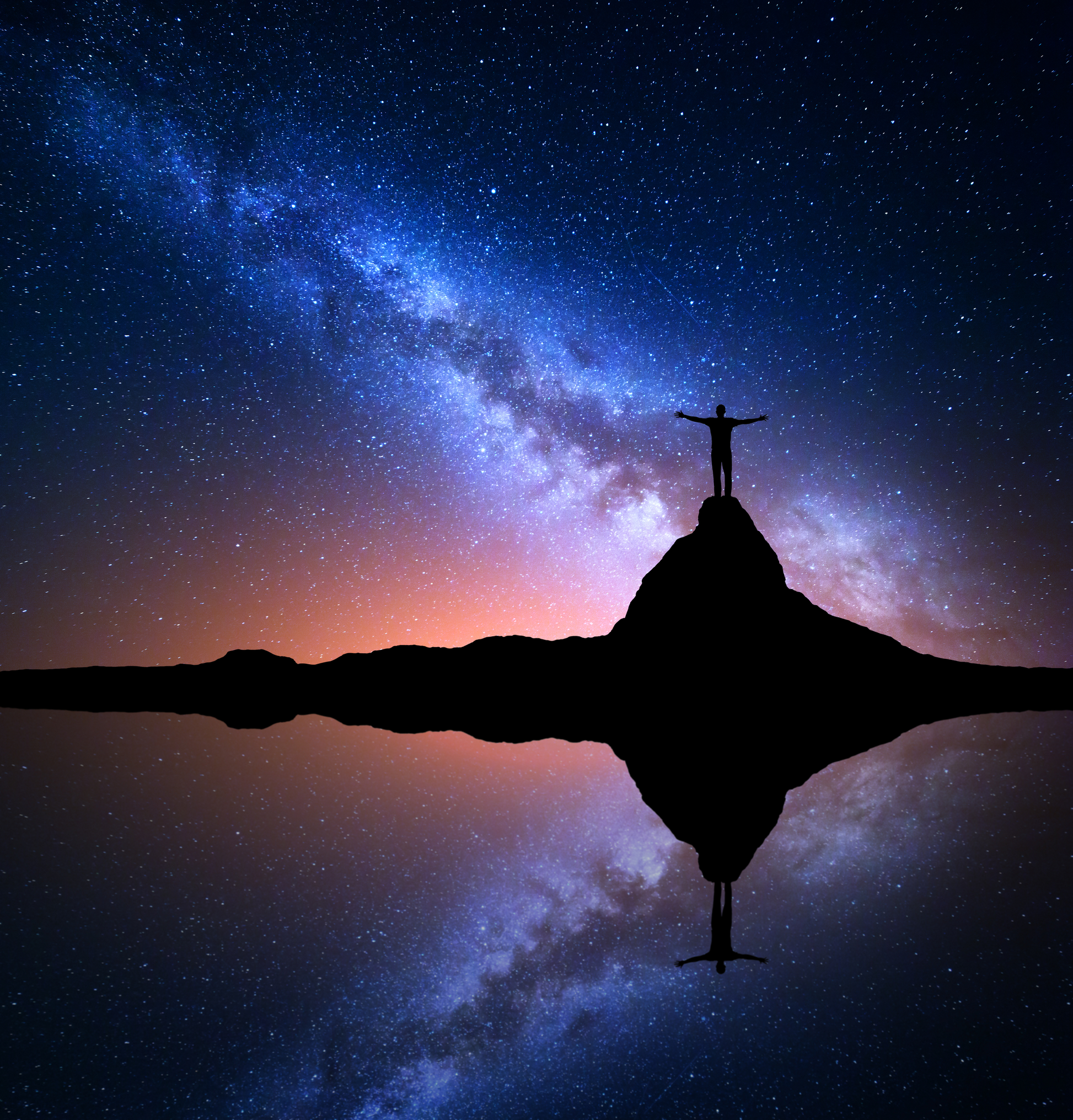 Silhouette einer Person auf einem Felsen unter einem leuchtenden Sternenhimmel mit Spiegelung im Wasser.